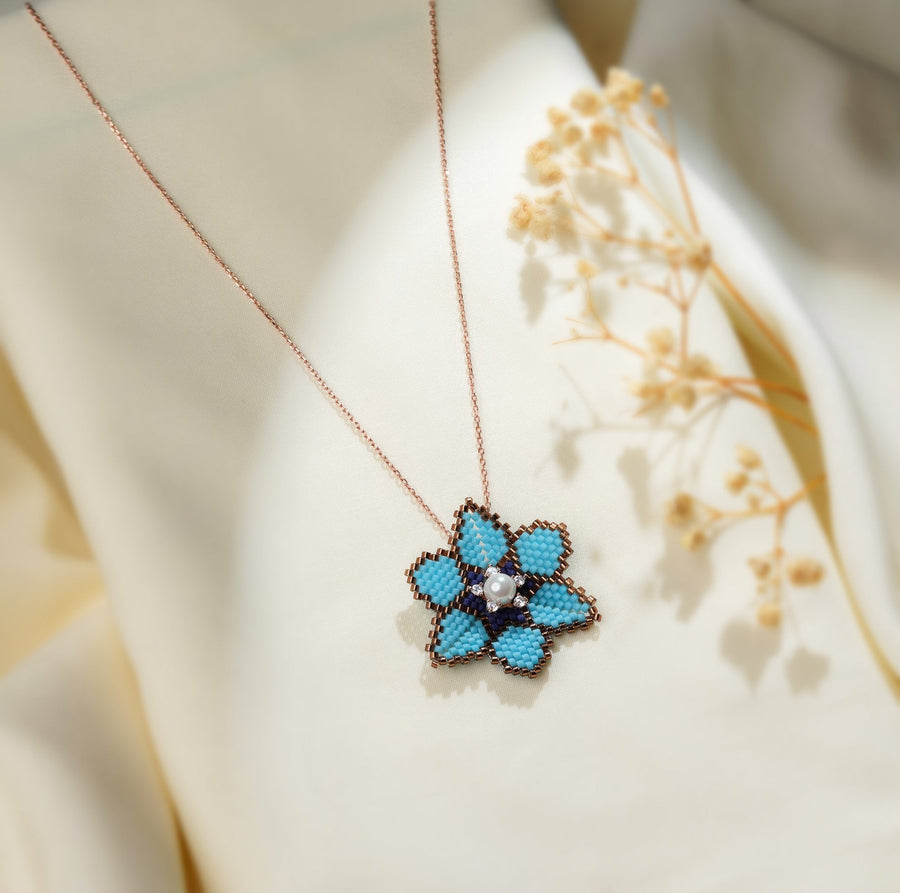 Turquoise beaded flower pendant on a rose-gold-tone chain