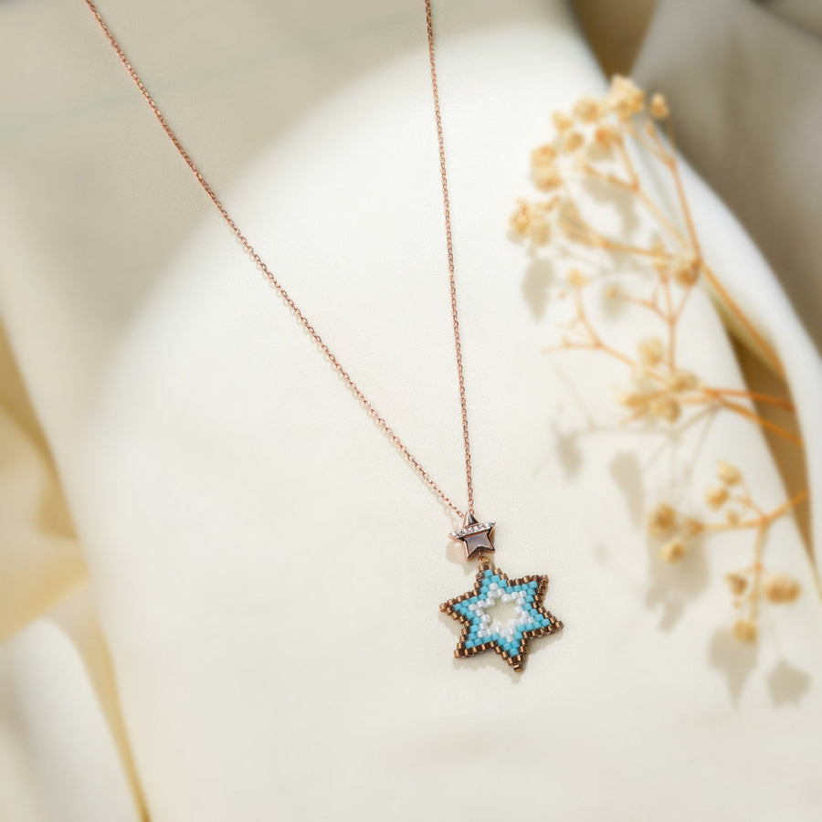 Turquoise beaded six-pointed star pendant on a rose-gold chain