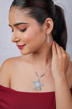 Model in red wearing the starfish necklace with a matching striped beaded drop earring