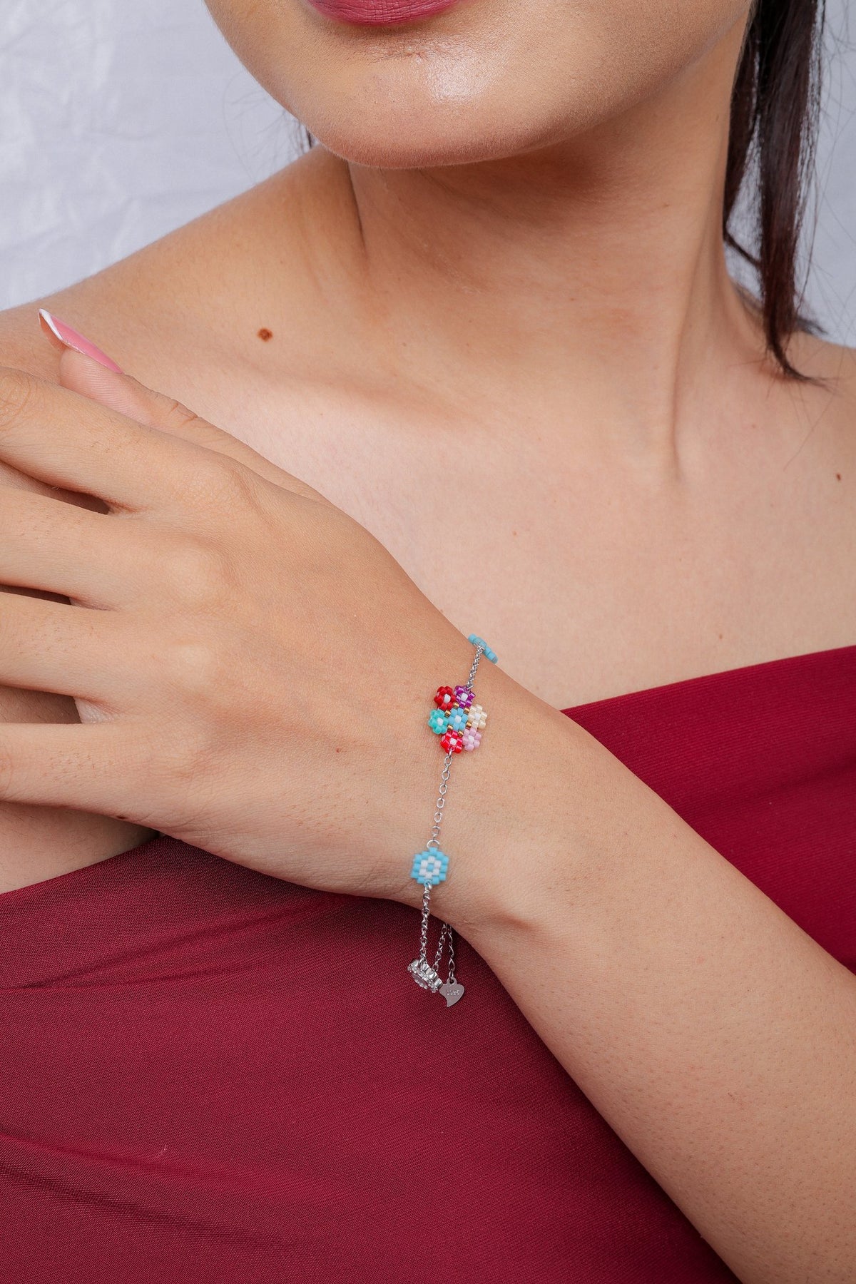 Flower cluster charm bracelet on the wrist, showing the crystal-set detail near the clasp