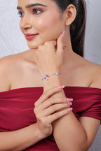 Model with hand at her chin wearing a dainty silver-tone flower cluster bracelet