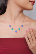 Silver chain necklace with five blue and turquoise beaded bird charms worn at the collarbone