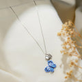 Silver chain necklace with a blue beaded butterfly pendant below a pearly heart and crystal butterfly