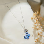 Silver chain necklace with a blue beaded butterfly pendant below a pearly heart and crystal butterfly