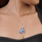 Angled view of blue butterfly pendant with pearly heart and crystal butterfly worn on model