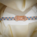 Woven bead bracelet with dusty-blue and blush daisy pattern and a rose-gold crystal centrepiece