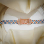 Woven bead bracelet with dusty-blue and blush daisy pattern and a rose-gold crystal centrepiece