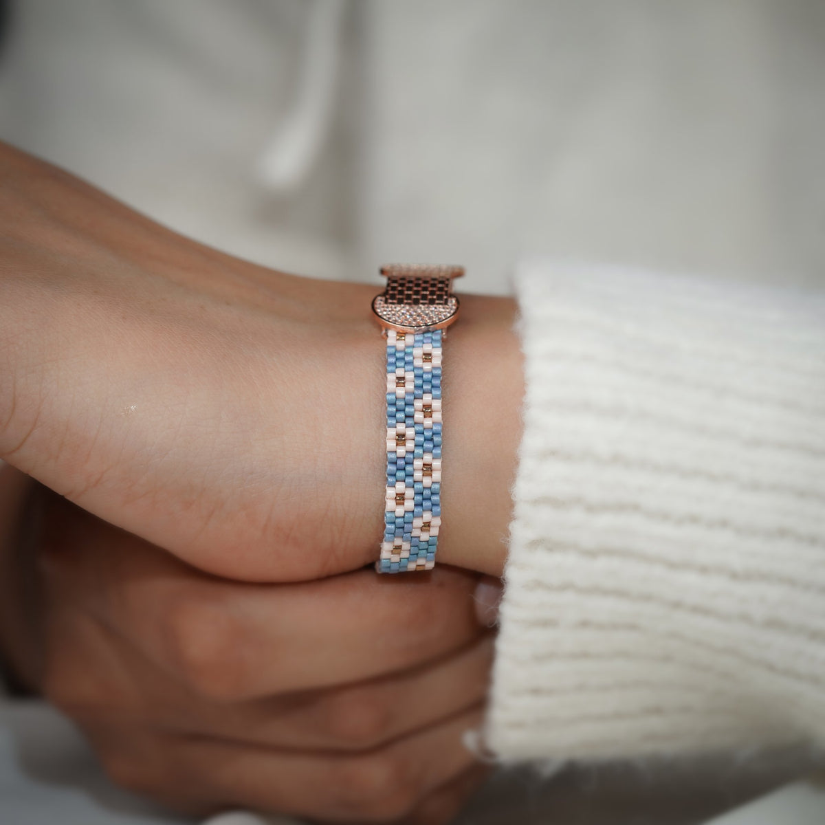 Blue and blush daisy loom bracelet with rose-gold centrepiece worn on the wrist