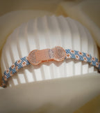 Angled view of rose-gold brick-textured centrepiece with crystal-studded ends on a daisy bead band