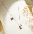 Rose-gold chain necklace with blue beaded elephant charm, engraved crystal tag and butterfly charm