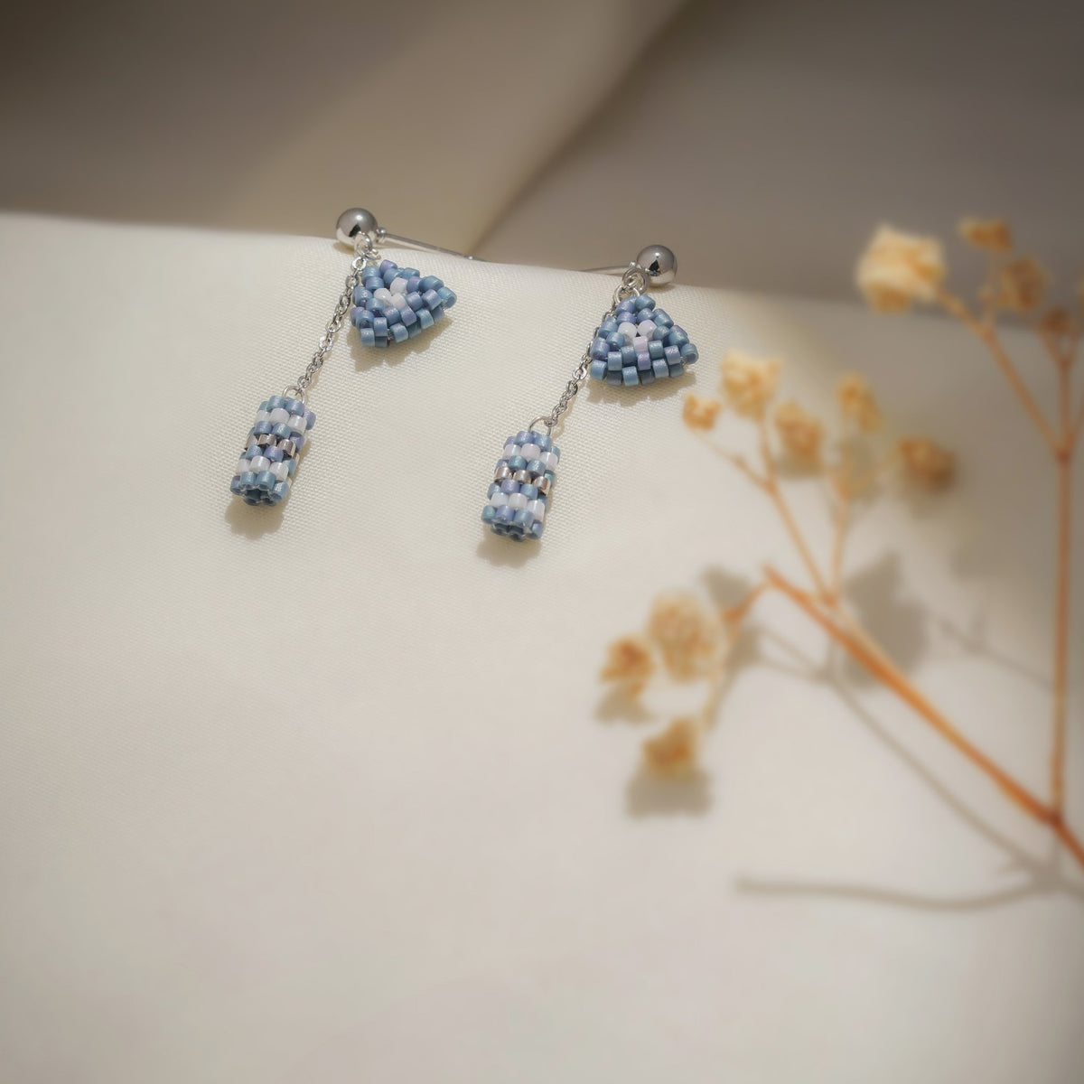Matching earrings: silver ball studs with blue beaded triangles and dangling beaded tubes
