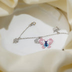 Pink and blue beaded butterfly with crystal charms on a silver chain bracelet