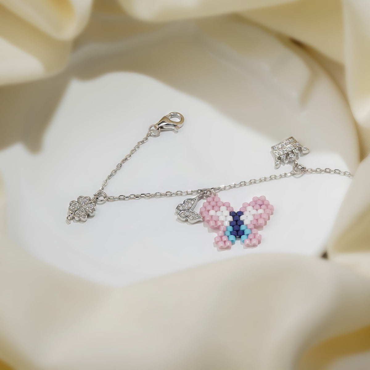 Pink and blue beaded butterfly with crystal charms on a silver chain bracelet