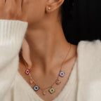 Model wearing the rose-gold beaded square and butterfly charm necklace with crystal stud earrings