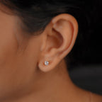 Close-up of a round crystal stud earring worn on the ear