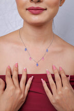 Model in a red off-shoulder top wearing a pink and blue fish charm necklace