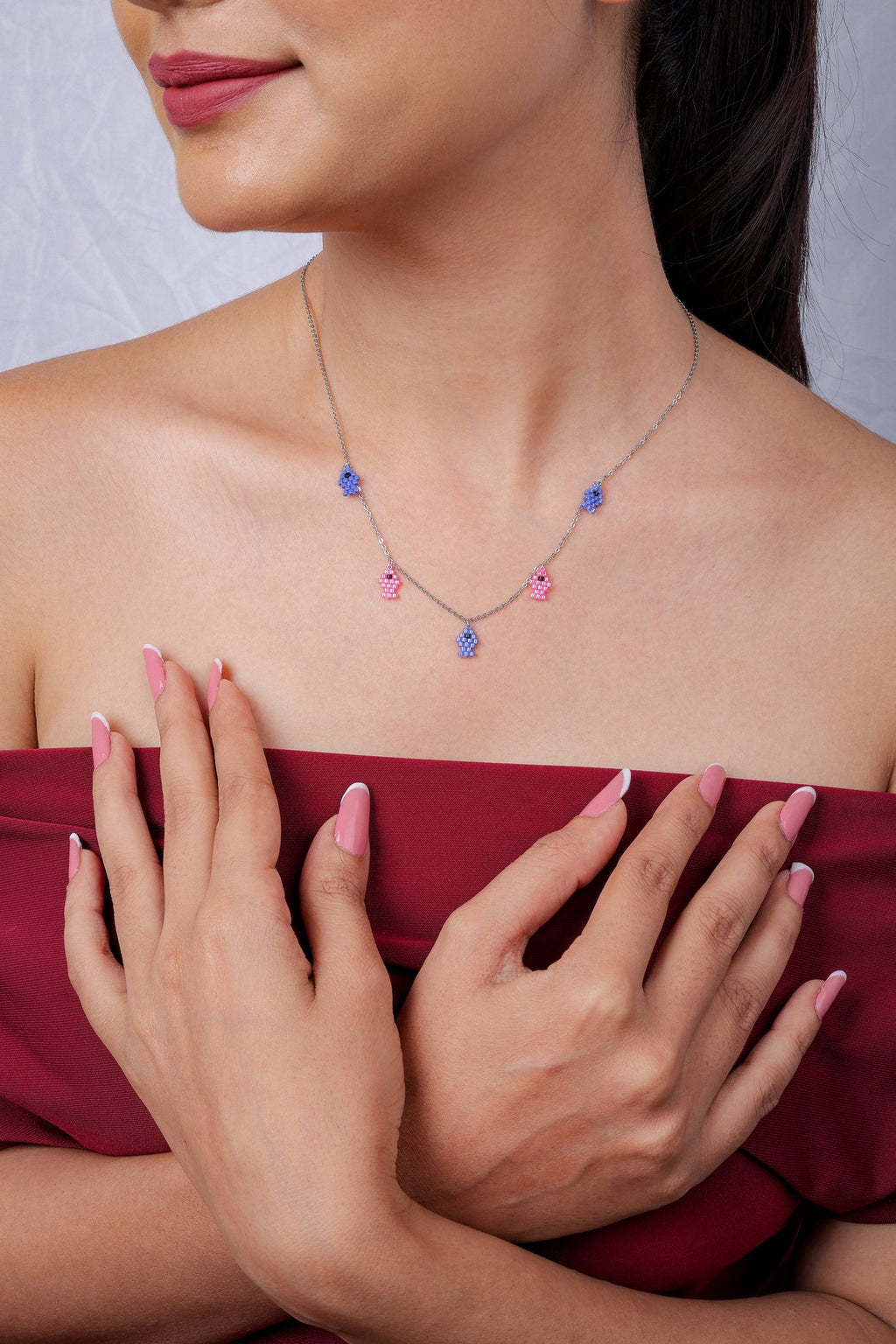 Fine silver-tone necklace with alternating blue and pink beaded fish charms