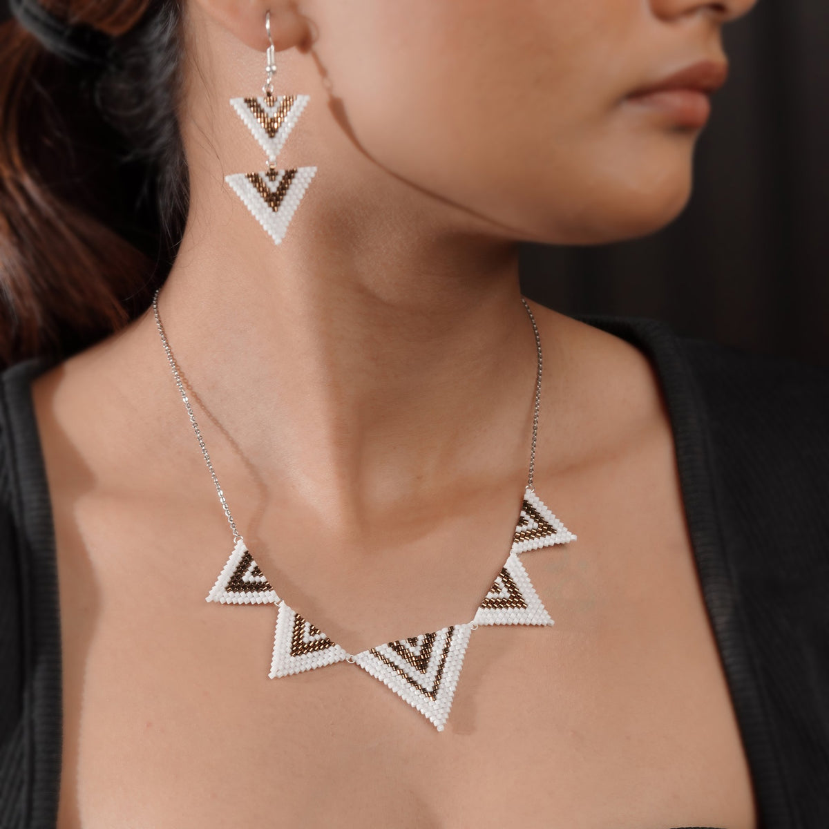 Model wearing chevron triangle necklace with matching double-triangle drop earrings