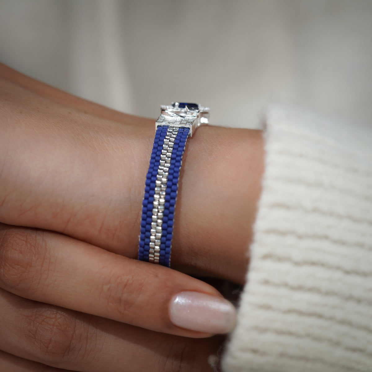 Cobalt woven bracelet with silver stripe and blue crystal centrepiece worn on the wrist