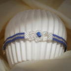 Front view of checkered silver plates, pavé ring and rectangular blue crystal on cobalt beaded band