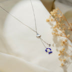 Close-up of cobalt and white beaded charm and pavé fan drop hanging from pearly white connector