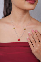 Silver chain necklace with red and lime beaded diamond pendant and two small diamond stations
