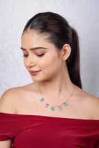 Model looking down, wearing a turquoise and grey duckling charm necklace