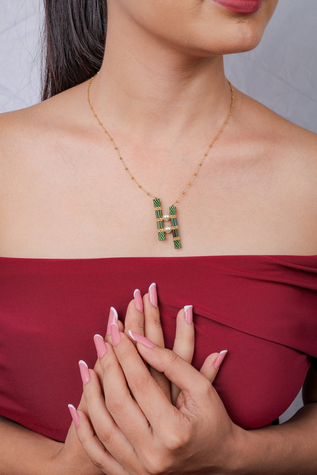 Gold-tone bead-station chain with a pendant of two green beaded bars joined by pearly beads