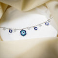 Silver charm bracelet with beaded evil eye, blue evil-eye discs and crystal star charms