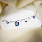 Silver charm bracelet with beaded evil eye, blue evil-eye discs and crystal star charms