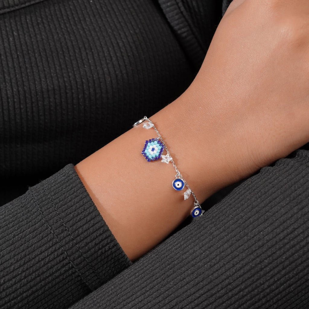 Evil eye charm bracelet with beaded centre charm and crystal stars worn on the wrist