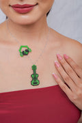 Silver chain necklace with green and black beaded guitar pendant and headphones charm on the neckline