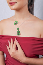 Model in a red off-shoulder top wearing the green beaded guitar and headphones charm necklace