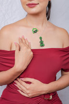 Model wearing the green beaded guitar and headphones necklace with hand on chest