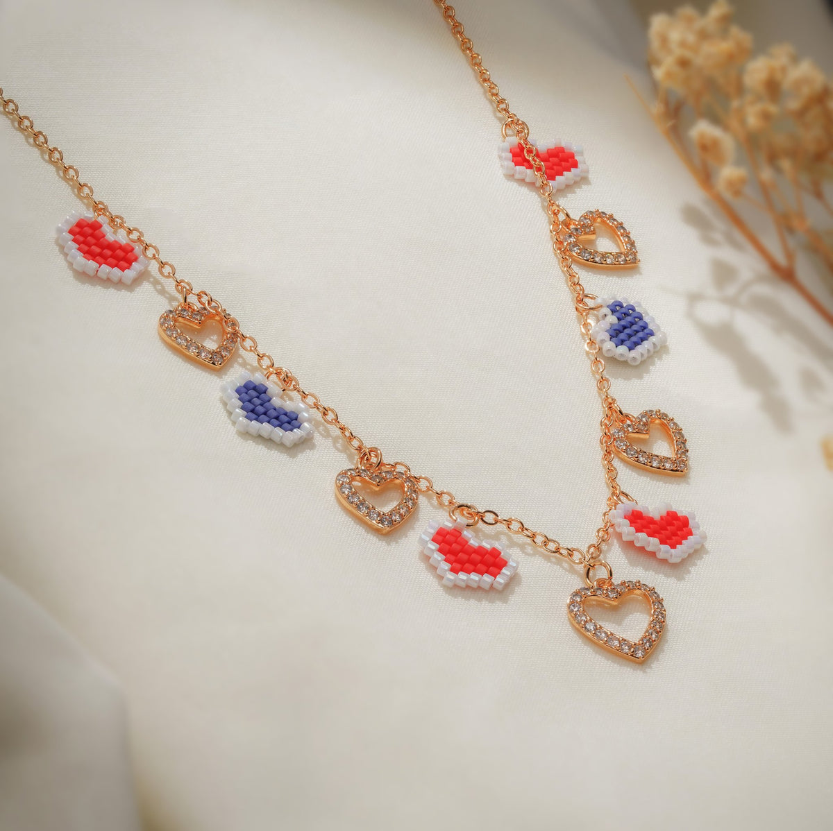 Close view of white-edged red and navy pixel hearts beside crystal-studded open hearts