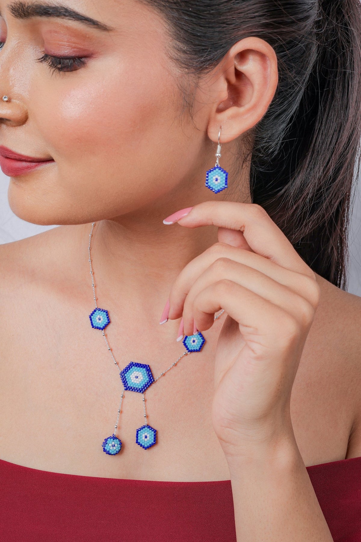 Close view of hexagon evil eye drop earring and Y-shaped necklace with two dangling eyes