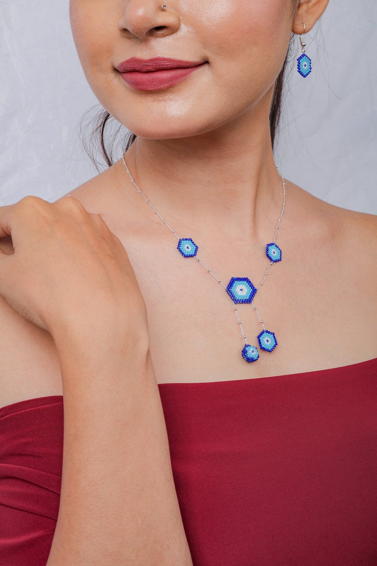 Model wearing cobalt and turquoise evil eye necklace set with matching earring