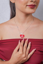 Model wearing the red beaded heart pendant with crystal Love charm on a silver chain