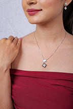 Model in red top wearing the ivory star pendant necklace with matching earring visible