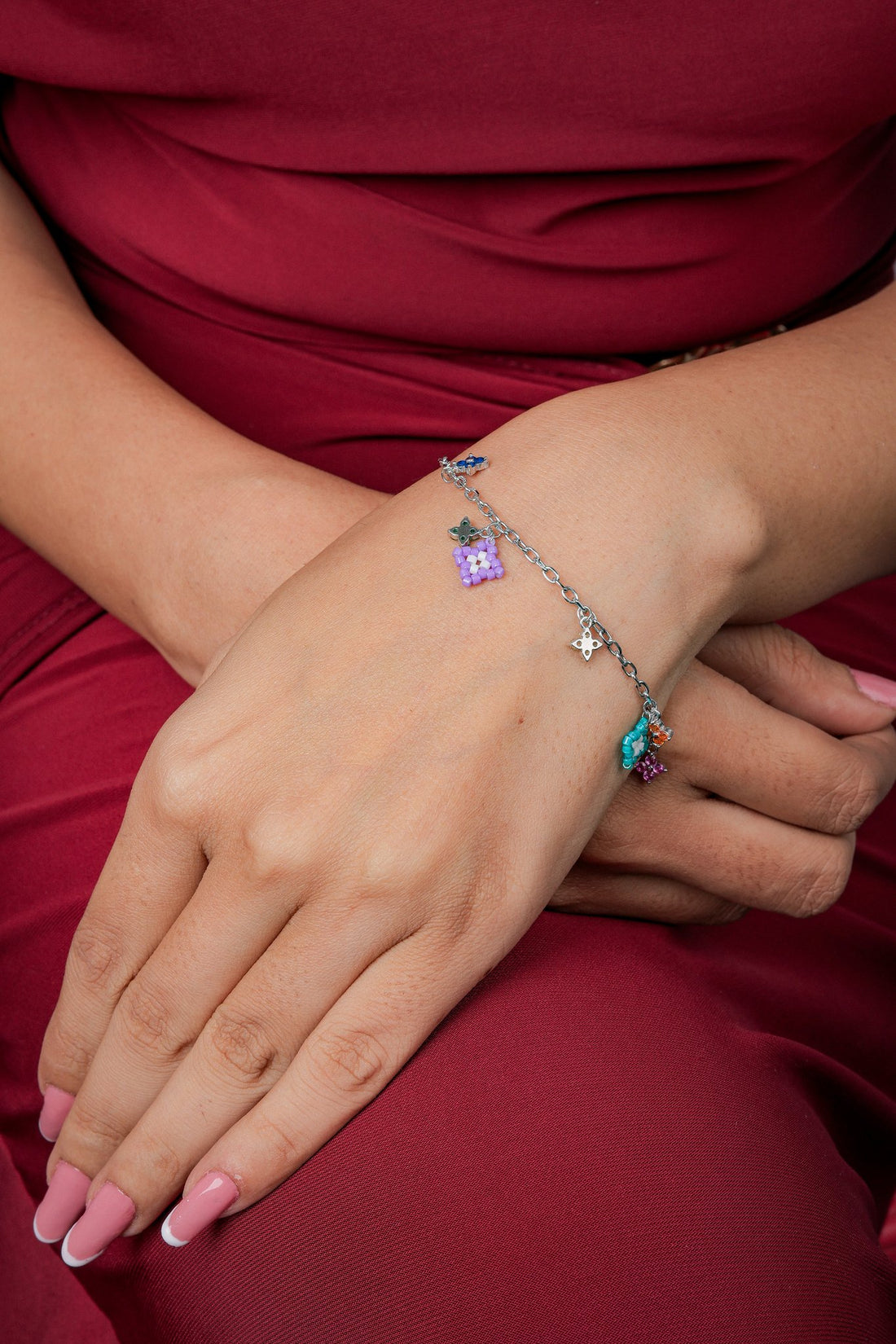 Silver charm bracelet with lilac beaded square and colourful crystal flower charms on the wrist