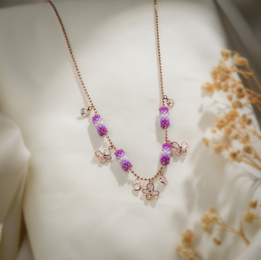 Rose-gold-tone ball chain necklace with purple beaded tubes and crystal butterfly charms