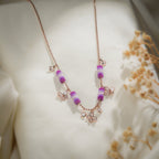 Rose-gold-tone ball chain necklace with purple beaded tubes and crystal butterfly charms