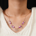 Model wearing a rose-gold-tone necklace with lilac bead tubes and crystal charms