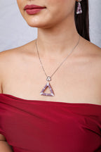 Close view of lilac beaded open-triangle pendant below a crystal heart-cluster connector