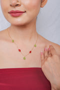 Gold chain necklace with lime-green beaded stars and red beaded diamond stations at the neckline