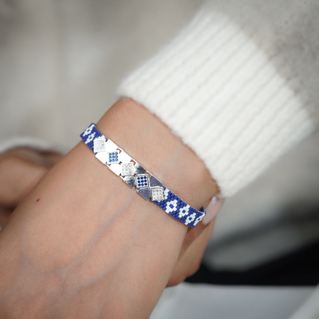Cobalt woven bracelet with silver-tone crystal squares worn on the wrist