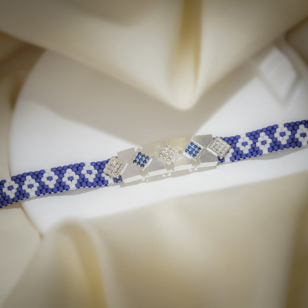 Cobalt loom band with white pixel flowers and pavé crystal square links on cream silk