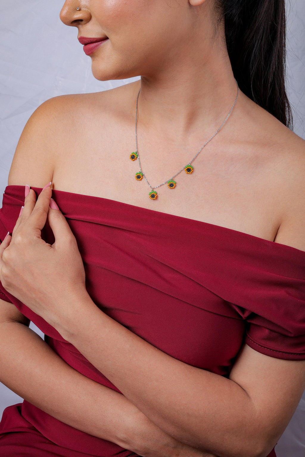 Model in red off-shoulder top wearing the fine silver chain with five small beaded charms