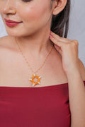 Gold bead-station chain necklace with an open orange and white beaded star pendant