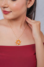 Gold bead-station chain necklace with an open orange and white beaded star pendant